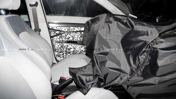 Das Innere eines Autos, teilweise mit einer schwarzen Plane abgedeckt, um Details zu verbergen.