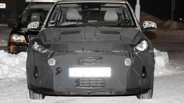 Ein Prototyp eines Autos mit Tarnung auf einer verschneiten Straße.