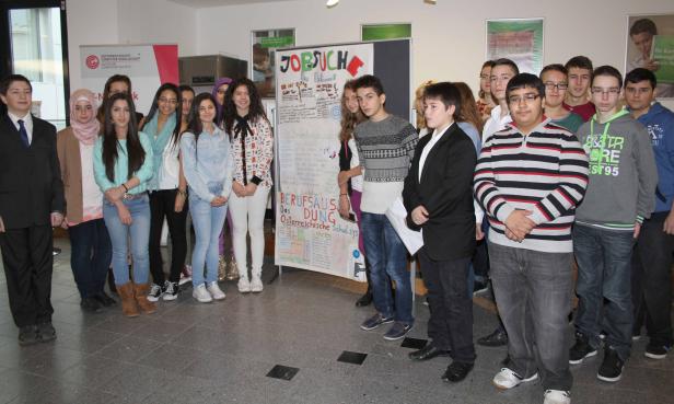 Eine Gruppe von Schülern steht vor einem Plakat zum Thema Berufsorientierung.