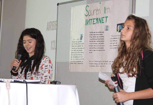 Zwei junge Frauen präsentieren ein Projekt zum Thema „Spuren im Internet“.