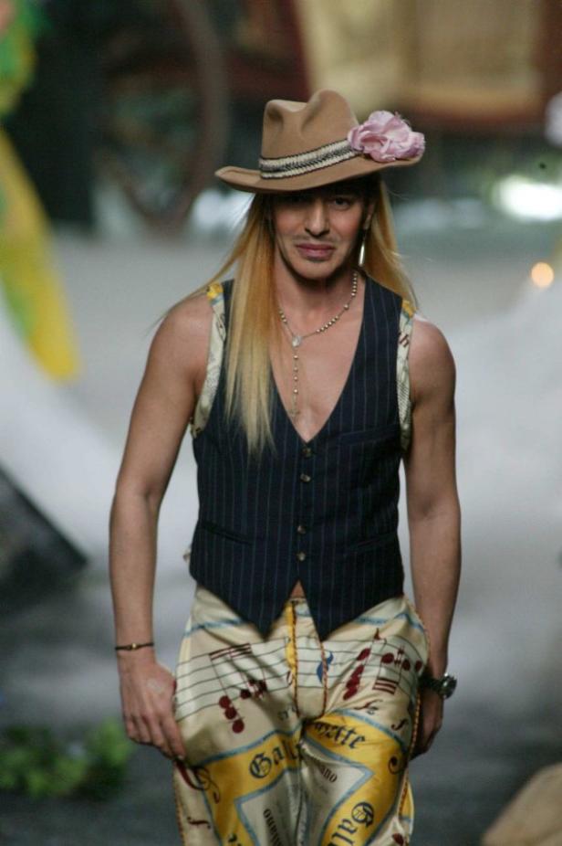 Ein Mann mit Hut, Weste und Hose mit Notenmuster auf einem Laufsteg.