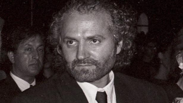 Ein Porträt von Gianni Versace mit lockigem Haar und Bart.