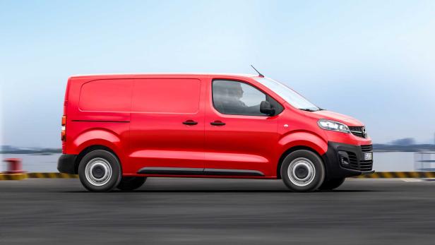 Ein roter Opel Vivaro Transporter fährt auf einer Straße.