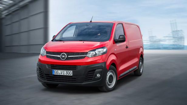 Ein roter Opel Transporter fährt auf einer Straße.