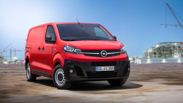 Ein roter Opel Vivaro Transporter vor einer Baustelle.