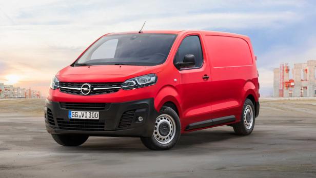 Ein roter Opel-Lieferwagen steht vor einer Baustelle.