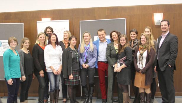 Eine Gruppe von Frauen und Männern posiert für ein Gruppenfoto.