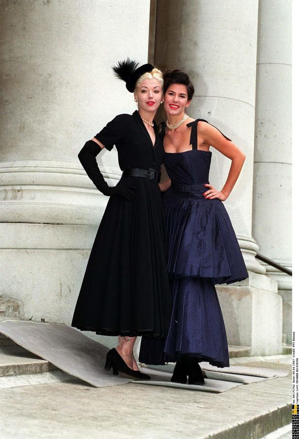 Tamara Beckwith und eine weitere Frau posieren in eleganten Kleidern vor einem Gebäude.