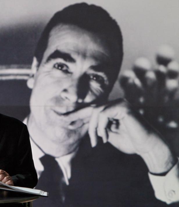 Eine Person steht vor einem Porträt von Ricardo Legorreta.