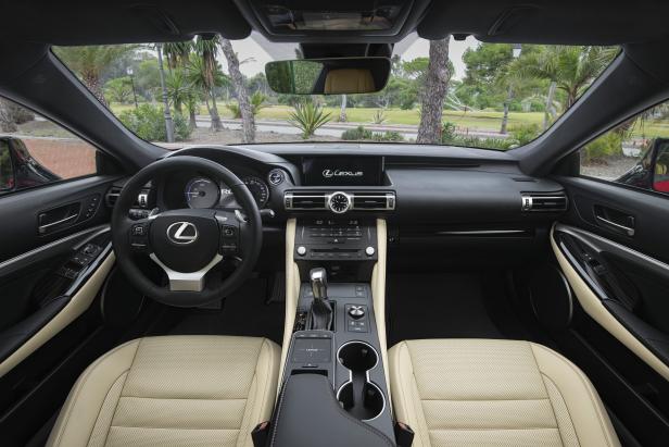 Innenansicht eines Lexus mit beigen Ledersitzen und Blick auf eine grüne Landschaft.
