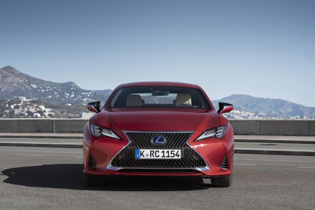 Ein roter Lexus RC steht vor einer Bergkulisse.