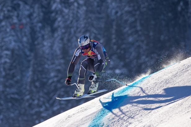 Ein Skirennläufer fährt eine schneebedeckte Piste hinunter.