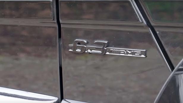 Nahaufnahme des „6.3 AMG“-Emblems an einem Auto.