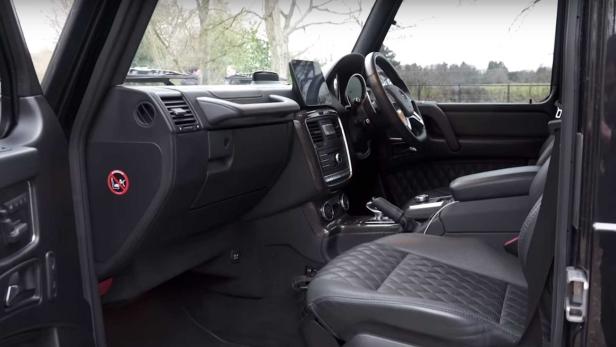 Innenraum eines schwarzen Mercedes-Benz G-Klasse mit Ledersitzen.