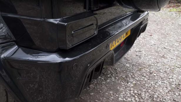 Detailansicht des Hecks eines schwarzen Geländewagens mit Reserverad und Nummernschild.