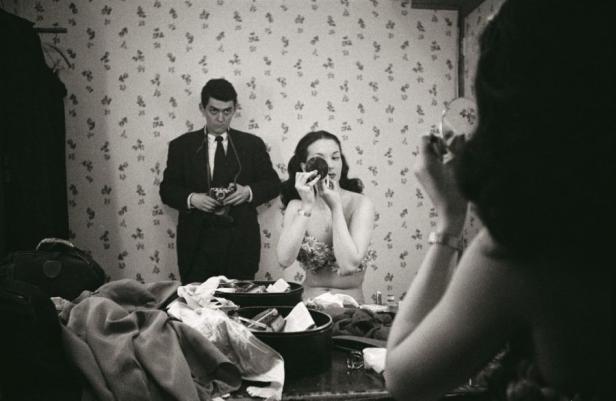 Stanley Kubrick fotografiert eine Frau, die sich vor einem Spiegel schminkt.