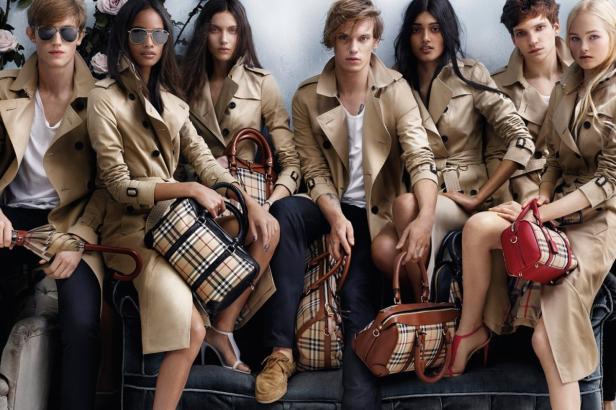 Eine Gruppe von Models präsentiert Trenchcoats und Handtaschen von Burberry.
