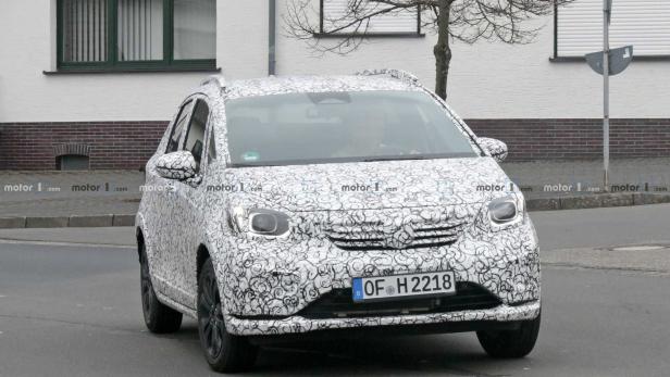 Ein mit einem Muster getarntes Auto fährt auf einer Straße.