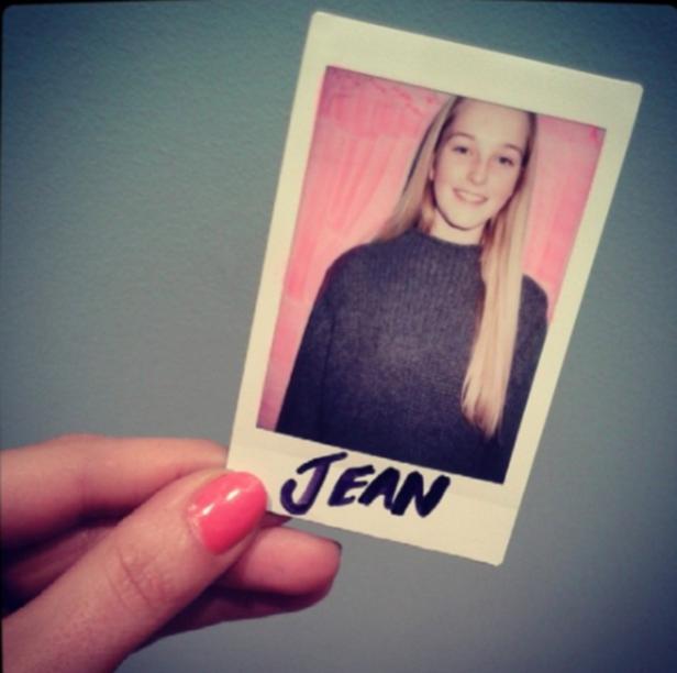 Eine Hand hält ein Polaroid-Foto von einer jungen Frau namens Jean.