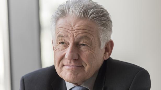 Porträt eines älteren Mannes mit grauem Haar im Anzug.