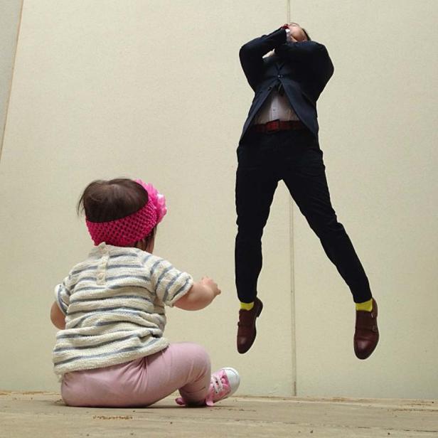 Ein Baby beobachtet einen Mann im Anzug, der in der Luft zu schweben scheint.