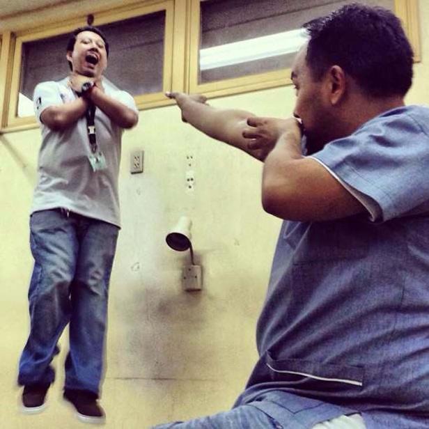 Ein Mann im blauen Hemd scheint einen anderen Mann zu erwürgen, der in der Luft schwebt.