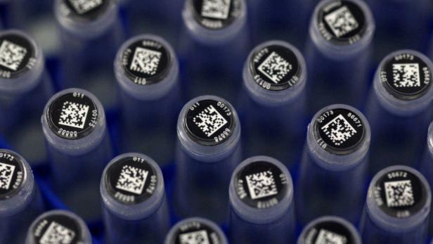 Nahaufnahme von blauen Röhrchen mit QR-Codes und Nummern auf den Deckeln.