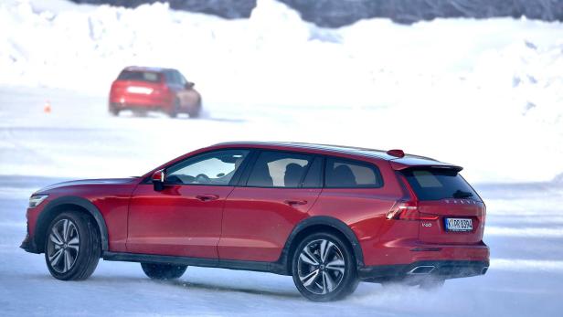 Ein roter Volvo V60 Cross Country fährt auf einer schneebedeckten Straße.