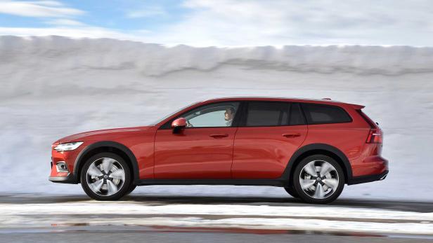 Ein roter Volvo V60 Cross Country fährt auf einer schneebedeckten Straße.