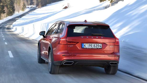 Ein roter Volvo V60 fährt auf einer schneebedeckten Straße.