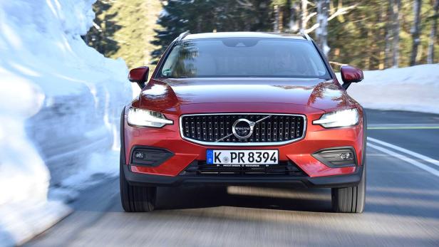 Ein roter Volvo fährt auf einer Straße mit Schnee am Straßenrand.