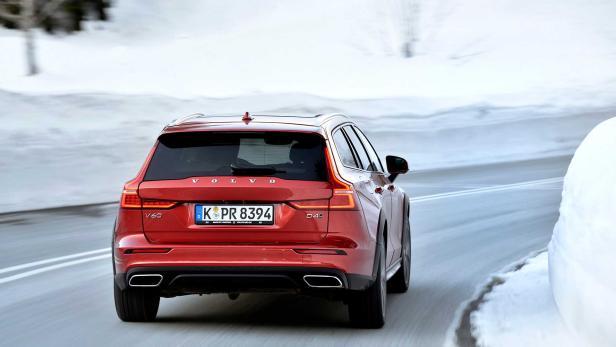Ein roter Volvo V60 Cross Country fährt auf einer schneebedeckten Straße.