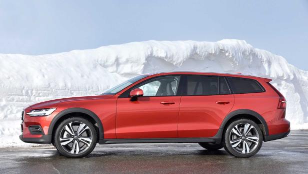 Ein roter Volvo V60 Cross Country steht vor einem Schneehaufen.
