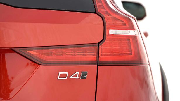 Detailansicht des Rücklichts und des D4 AWD-Emblems eines roten Autos.