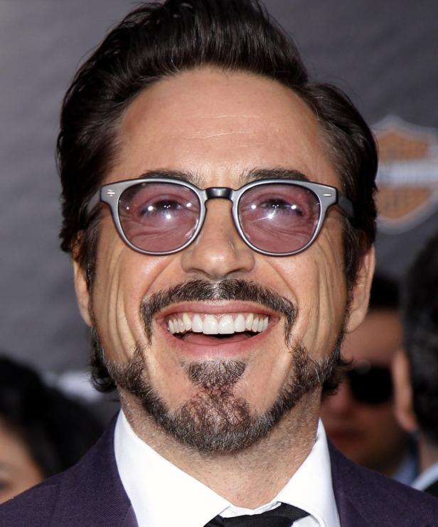 Robert Downey Jr. lächelt mit Brille und Bart in die Kamera.