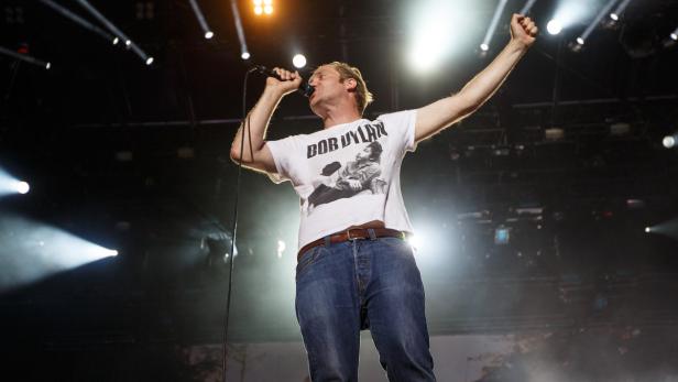 Ein Sänger mit einem Bob Dylan T-Shirt tritt auf einer Bühne auf.