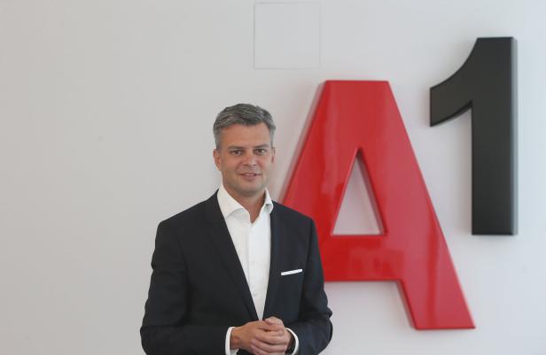 Ein Mann im Anzug steht vor dem A1-Logo.