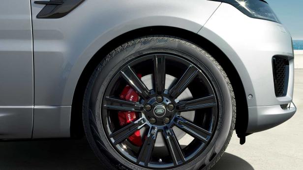 Nahaufnahme eines silbernen Range Rover mit schwarzen Felgen und roten Bremssätteln.