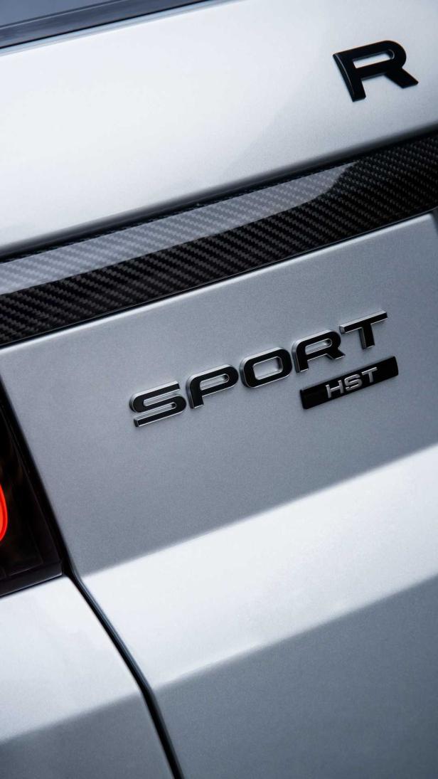 Detailansicht der „Sport HST“-Plakette an einem silbernen Range Rover.