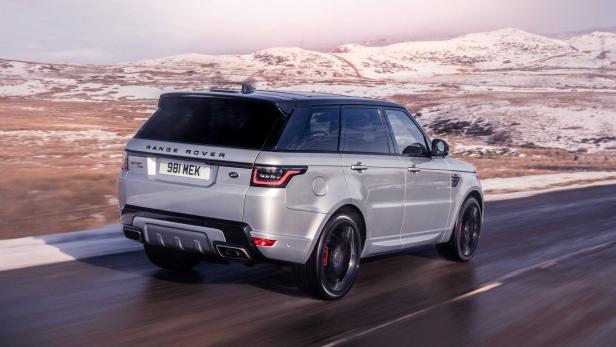 Ein silberner Range Rover Sport fährt auf einer Straße vor einer verschneiten Landschaft.