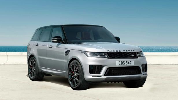 Ein silberner Range Rover Sport steht vor einem blauen Himmel und Meer.