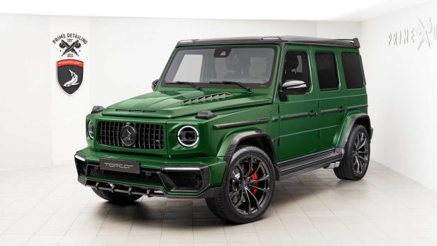 Ein grüner Mercedes-Benz G-Klasse Geländewagen steht in einem Studio.