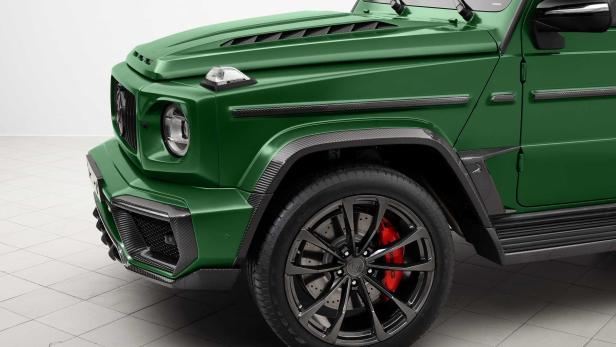 Detailansicht eines grünen Mercedes-Benz G-Klasse mit Karbonfaser-Akzenten und roten Bremssätteln.