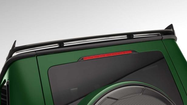 Detailansicht eines grünen Geländewagens mit Gepäckträger und Heckspoiler aus Carbon.