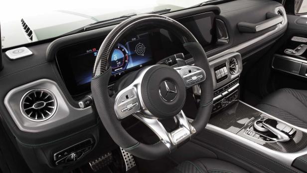 Innenraum eines Mercedes-AMG mit Carbon-Lenkrad und digitalen Anzeigen.