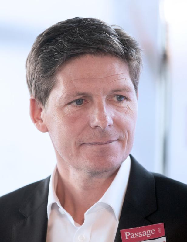 Ein Mann mit Anzug und Namensschild „Passage“.