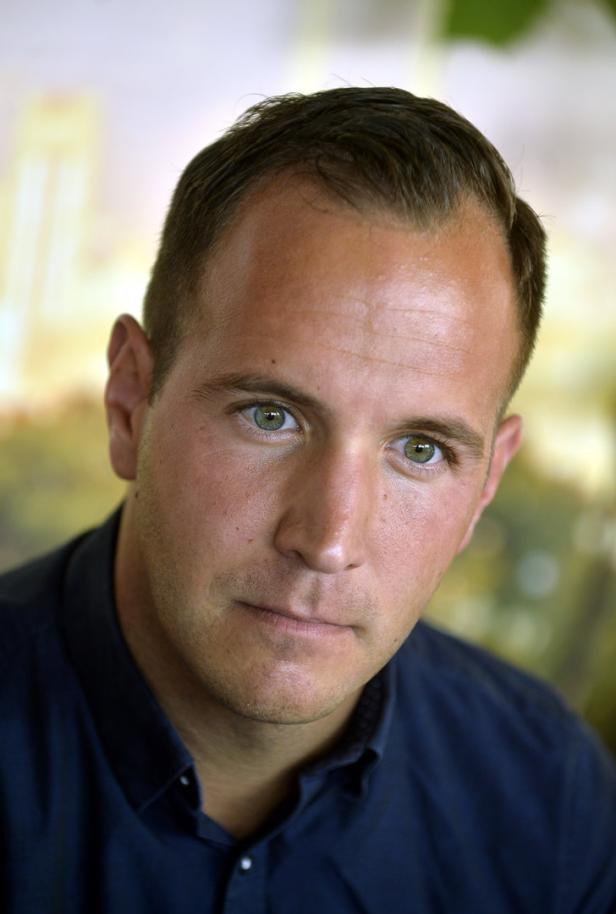 Porträt eines Mannes mit kurzen Haaren und hellen Augen.