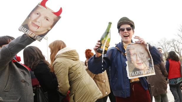 Keine Trauer um Thatcher: Party in Brixton Menschen feiern mit Champagner und Zeitungen mit dem Titel „Thatcher Dies“.