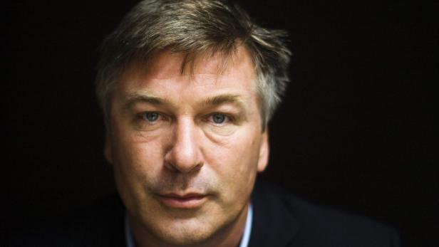 Porträt von Alec Baldwin vor einem dunklen Hintergrund.