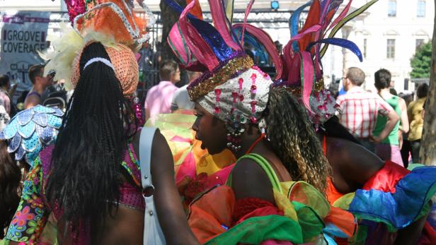 Zwei Frauen in farbenfrohen Karnevalskostümen und Kopfbedeckungen.